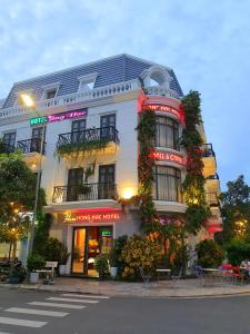 um edifício branco com plantas na lateral em Hồng Hạc Hotel em Tuy Hoa