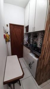 a small kitchen with a white table and a door at Suite completa independente, Metrô, rodoviária, Copacabana em 10 minutos, SmarTV in Rio de Janeiro