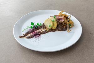 a white plate of food on a table at Hotel U Kříže in Prague