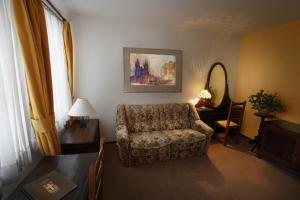 a living room with a chair and a table at Hotel U Kříže in Prague