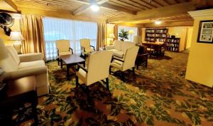 - un salon avec des chaises blanches et une table dans l'établissement Romantic Studio in the Heart of Palm Beach, à Palm Beach