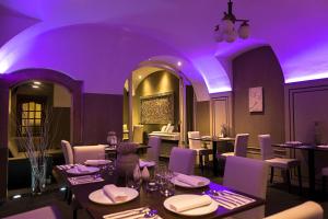 a purple lighting in a restaurant with tables and chairs at Hotel U Kříže in Prague