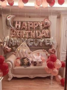 a room with a bed with a happy birthday sign and balloons at Royal Holiday Hanoi Hotel in Hanoi