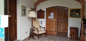een woonkamer met een stoel en een deur bij La Regibussa - Hotel Ristorante in Asti