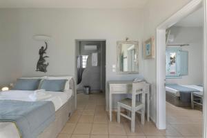 a bedroom with a bed and a table with a mirror at Blue Dolphins Apartments in Firostefani