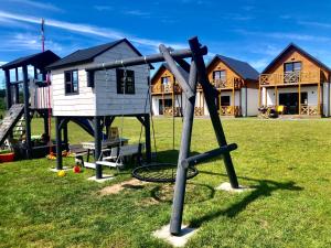 un parque infantil en un patio con casas al fondo en SŁONECZNE TARASY, en Gąski