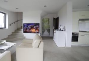 ein weißes Wohnzimmer mit einer weißen Couch und einer Küche in der Unterkunft Passivhaus 750m vom Bodensee -- 2x E-bike inklusive -- Neubau 2019 am Ortsrand in Öhningen
