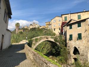 un viejo puente de piedra en una ciudad con edificios en Affitta camere Da Lalla, en Dolcedo