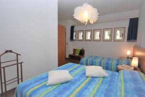sypialnia z 2 łóżkami i żyrandolem w obiekcie Villa Isolina w Lignano Sabbiadoro