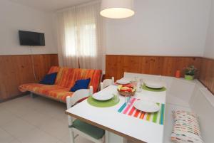 salon ze stołem i kanapą w obiekcie Villa Isolina w Lignano Sabbiadoro