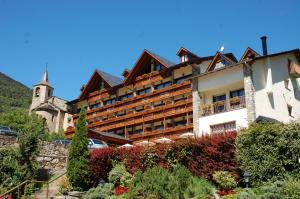 a large building with a garden in front of it at Hotel La Morera in Valencia de Aneu