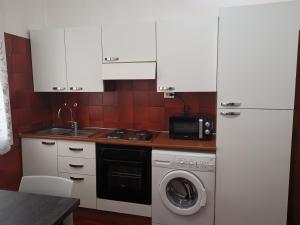 una cucina con lavatrice e forno a microonde di RES Clara a Padova