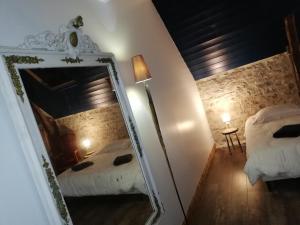 einen Spiegel in einem Zimmer mit 2 Betten in der Unterkunft Le Puits de Garival in Tour-de-Faure