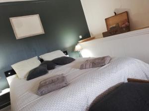 Un dormitorio con una gran cama blanca con almohadas. en Le Puits de Garival en Tour-de-Faure