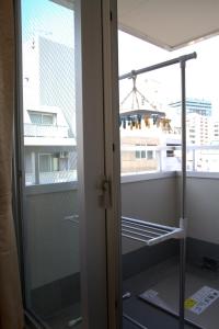 szklanymi drzwiami na balkon z widokiem na budynek w obiekcie 上野之家分館家庭房 w Tokio