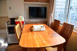 a dining room table with chairs and a television at 上野之家分館家庭房 in Tokyo