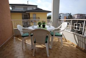 a white table and chairs on a balcony at Residenza Gardenia in Lignano Sabbiadoro
