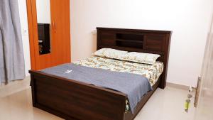 a bed in a bedroom with a wooden bed frame at Chippy Apartments No23 in Chennai