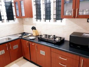 a kitchen with a stove top on a counter at Chippy Apartments No23 in Chennai