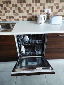 an oven with its door open in a kitchen at Hillock Residence Gozo Marsalforn in Marsalforn