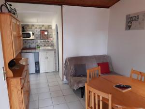 eine Küche und ein Esszimmer mit einem Tisch und einem Sofa in der Unterkunft L'escale du voyageur in Saint-Gaudens