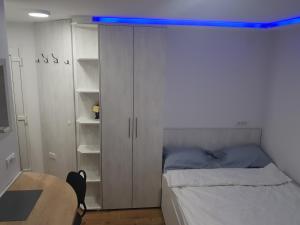 a bedroom with a bed with a blue light above it at studio skadarlija in Belgrade +5 photos