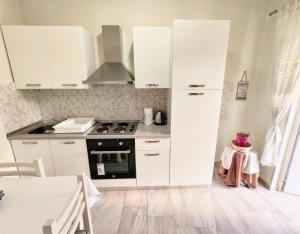 a kitchen with white cabinets and a stove at Tirana City Center Apartment in Tirana