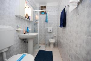 La petite salle de bains est pourvue de toilettes et d'un lavabo. dans l'établissement Residenza Cristallo, à Lignano Sabbiadoro