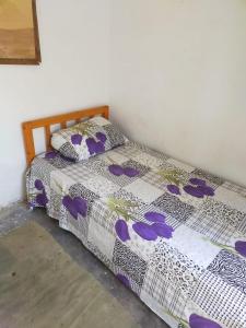 a bedroom with a bed with a white and purple comforter at November Camp in Dahab