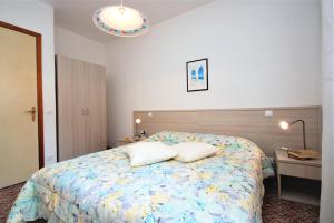 - une chambre avec un lit et 2 oreillers dans l'établissement Villa Ralph, à Lignano Sabbiadoro