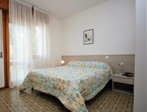 a hotel room with a bed and a window at Villa Ralph in Lignano Sabbiadoro