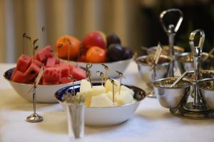 a table with bowls of fruit on a table at Ekaterina Hotel in Saint Petersburg