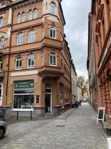 un bâtiment en briques dans une rue d'une ville dans l'établissement Jena Paradies, à Iéna