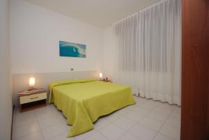 リニャーノ・サッビアドーロにあるAppartamenti Laraのベッドルーム1室(緑の毛布付きのベッド1台付)