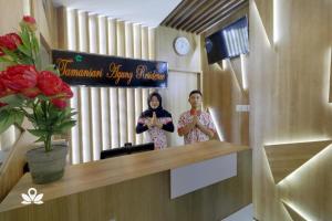 twee vrouwen in een kamer met een bord bij Tamansari Agung Residence in Jakarta