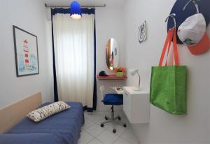 リニャーノ・サッビアドーロにあるAppartamenti Alidecoのベッド、デスク(緑の袋付)が備わる客室です。