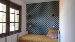 Le Breuil-en-AugeにあるGîte LA SAGESSEの模様のある壁とベッドと窓のある寝室 +6枚の写真