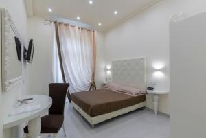 モンテカティーニ・テルメにあるホテル コロンビア ウェルネス＆スパのベッドルーム1室(ベッド1台、デスク、テーブル付)