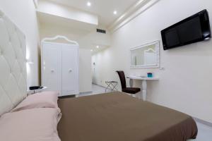 1 dormitorio con 1 cama, TV y escritorio en Hotel Columbia Wellness & Spa, en Montecatini Terme