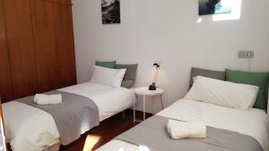 Habitación con 2 camas individuales y mesa. en Pensión Les Eres, en Puebla de Vallbona