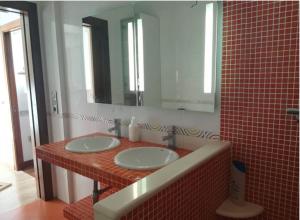 baño con 2 lavabos y espejo grande en Pensión Les Eres, en Puebla de Vallbona