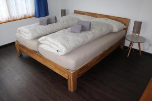 a bed with two pillows on top of it at Ferienwohnung für 5 Personen in Cumpadials, inmitten der Surselva in Sumvitg