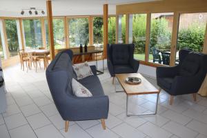 een woonkamer met blauwe stoelen en een tafel bij Ferienwohnung für 5 Personen in Cumpadials, inmitten der Surselva in Sumvitg