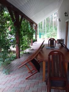 a wooden table and chairs on a patio at Pensjonat agroturystyczny Sosnówka - KOSARZYN in Kosarzyn