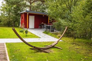 a pair of hammocks in the grass in front of a red shed at The Paddock B&B in Müllenbach