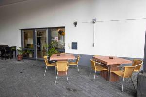 two wooden tables and chairs in front of a building at The Paddock B&B in Müllenbach +6 photos