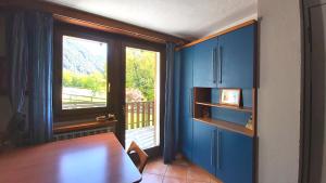 Un comedor con una mesa y un gran ventanal. en Mont Blanc Apartment Morgex, en Morgex