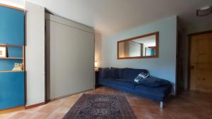 sala de estar con sofá azul y espejo en Mont Blanc Apartment Morgex, en Morgex