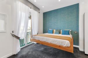 a bedroom with a bed with a blue wall at President Plaza Vip Suite Spa by Babylon Stay in Naples