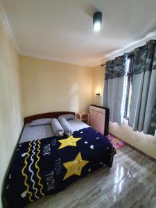 a bedroom with a bed with stars on it at VILLA PANDA G Kota Bunga Puncak in Cinengangirang